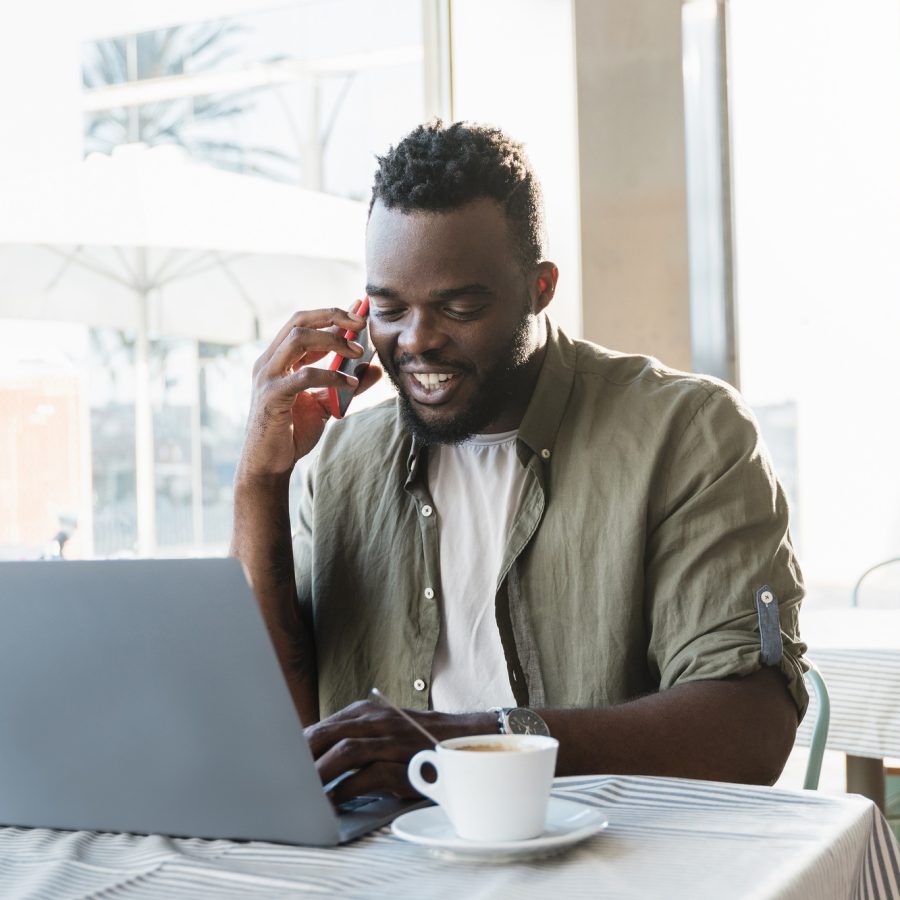 Young african freelancer man working at coffee bar with laptop computer - Focus on face